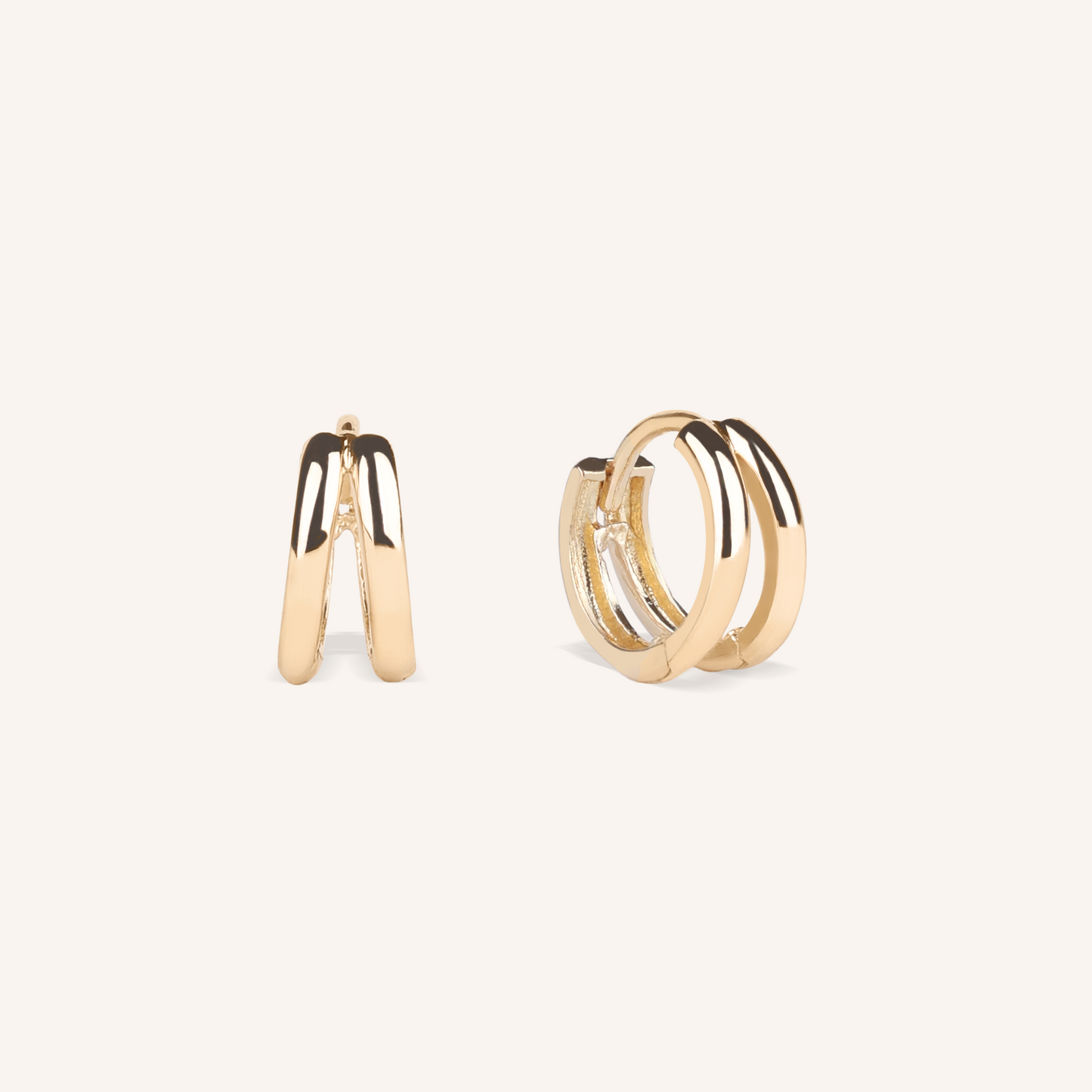 Gold hoop earrings on a light beige background