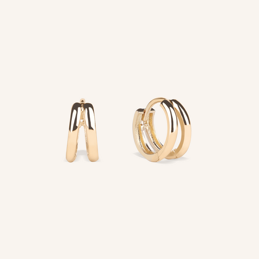 Gold hoop earrings on a light beige background