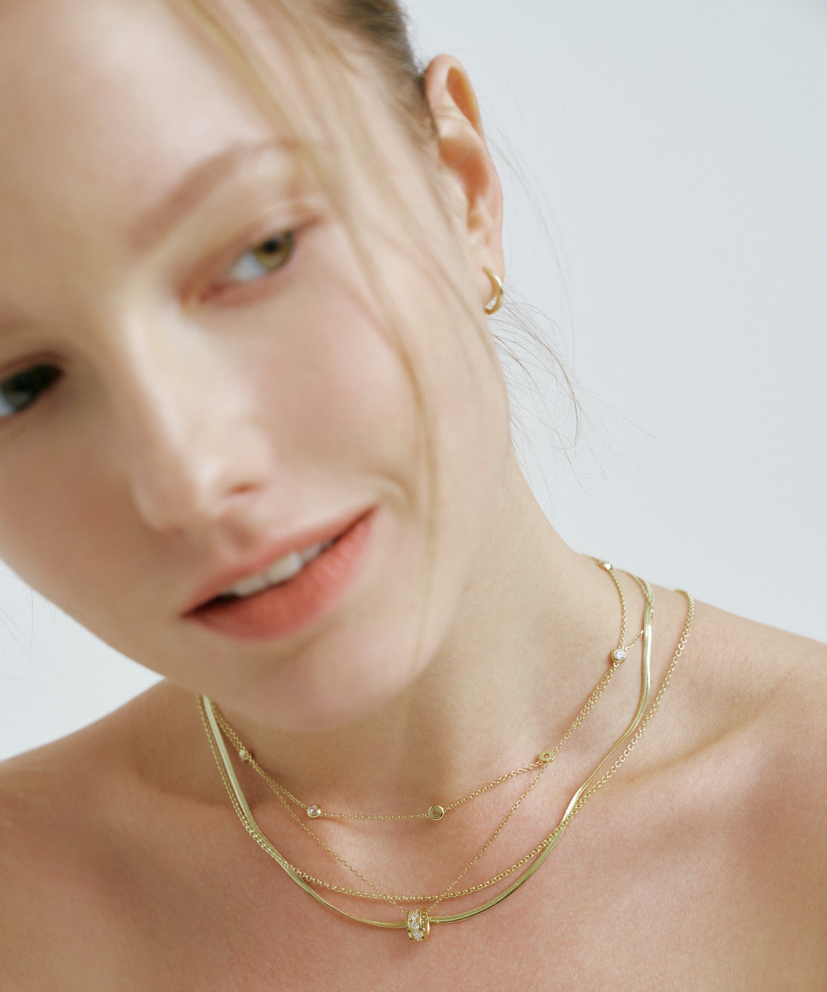 Yellow Gold | Lab Grown Diamond Bezel Station Necklace, 8 Stones, worn, head tilted toward the camera