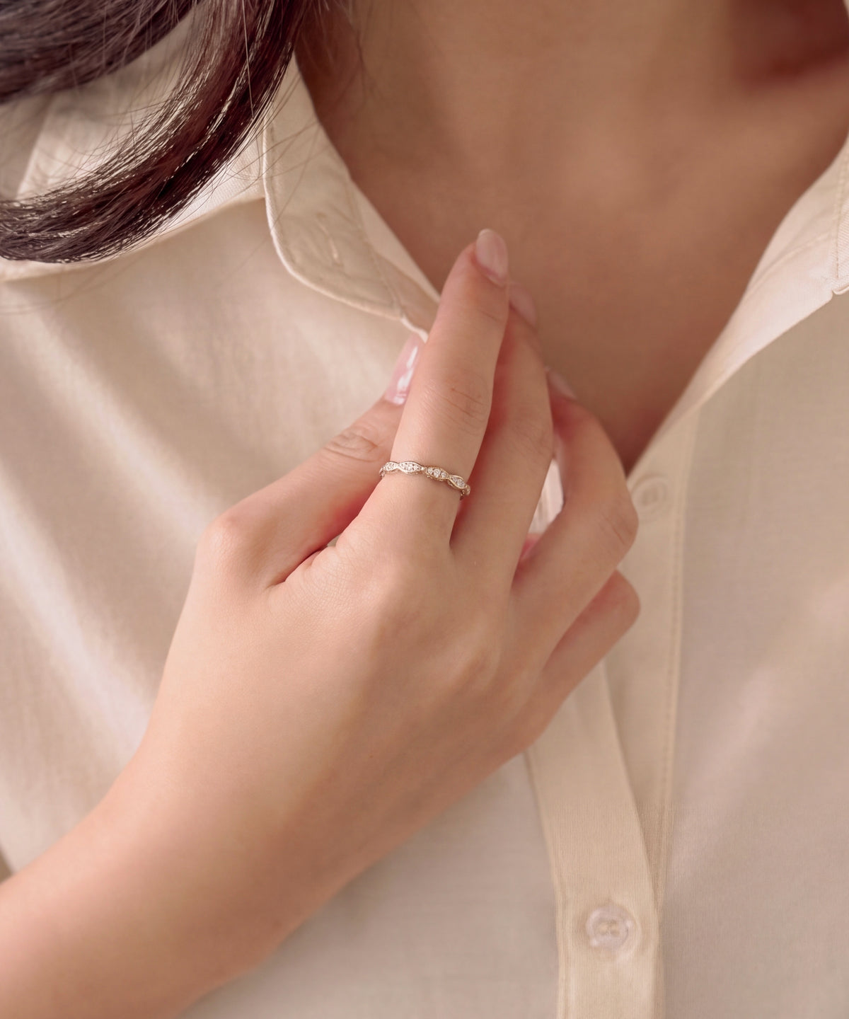 Milgrain marquise eternity band worn on the index finger, hand resting at a shirt collar